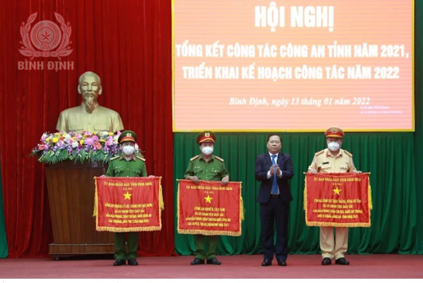Đồng chí Nguyễn Phi Long, Chủ tịch UBND tỉnh trao cờ cho Công an huyện Tây Sơn ( thứ hai từ trái sang).