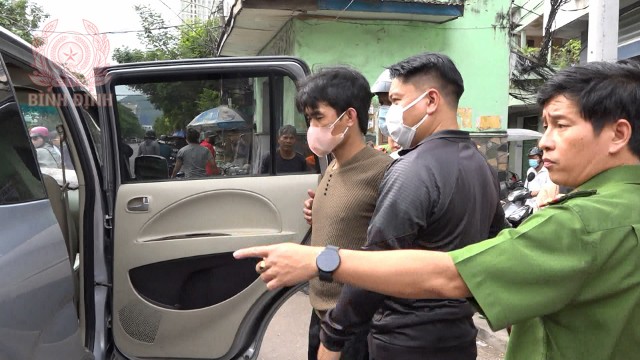 Cơ  quan chức năng đưa đối tượng Lê Minh Nhật (áo nâu) về nơi tạm giam để phục vụ công tác điều tra