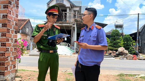 Thượng úy Nguyễn Văn Chiến trao đổi với kiểm sát viên tại hiện trường vụ trộm ở xã Nhơn Khánh.
