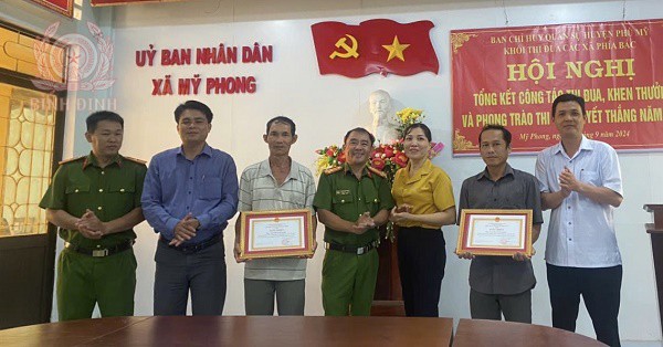 Đồng chí Thượng tá Đặng Minh Thanh, Phó Trưởng Công an huyện Phù Mỹ trao Giấy khen của Giám đốc Công an tỉnh  cho 02 công dân của xã Mỹ Phong.