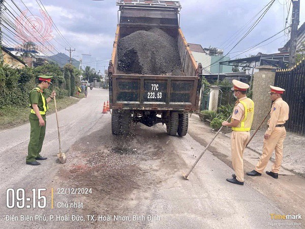 Cảnh sát giao thông Công an thị xã Hoài Nhơn kịp thời san lấp “ổ voi” giúp người dân lưu thông an toàn.